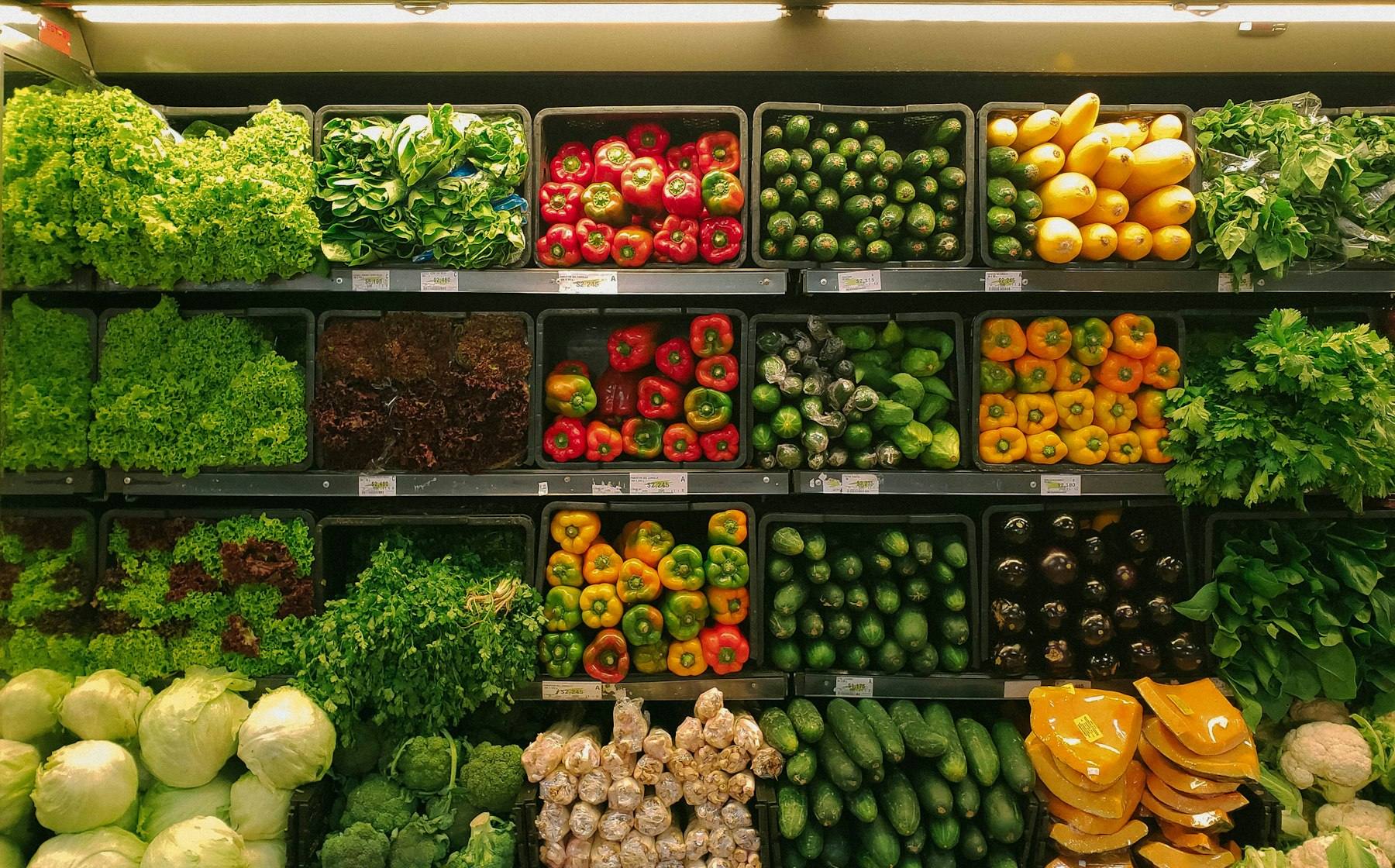 Fresh produce stacked by the case along the shelves of a wholesale market floor