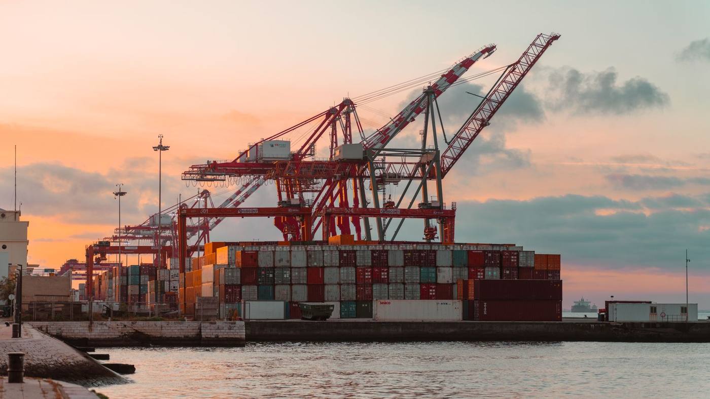 Gantry cranes over a loaded quay at a container terminal at dusk