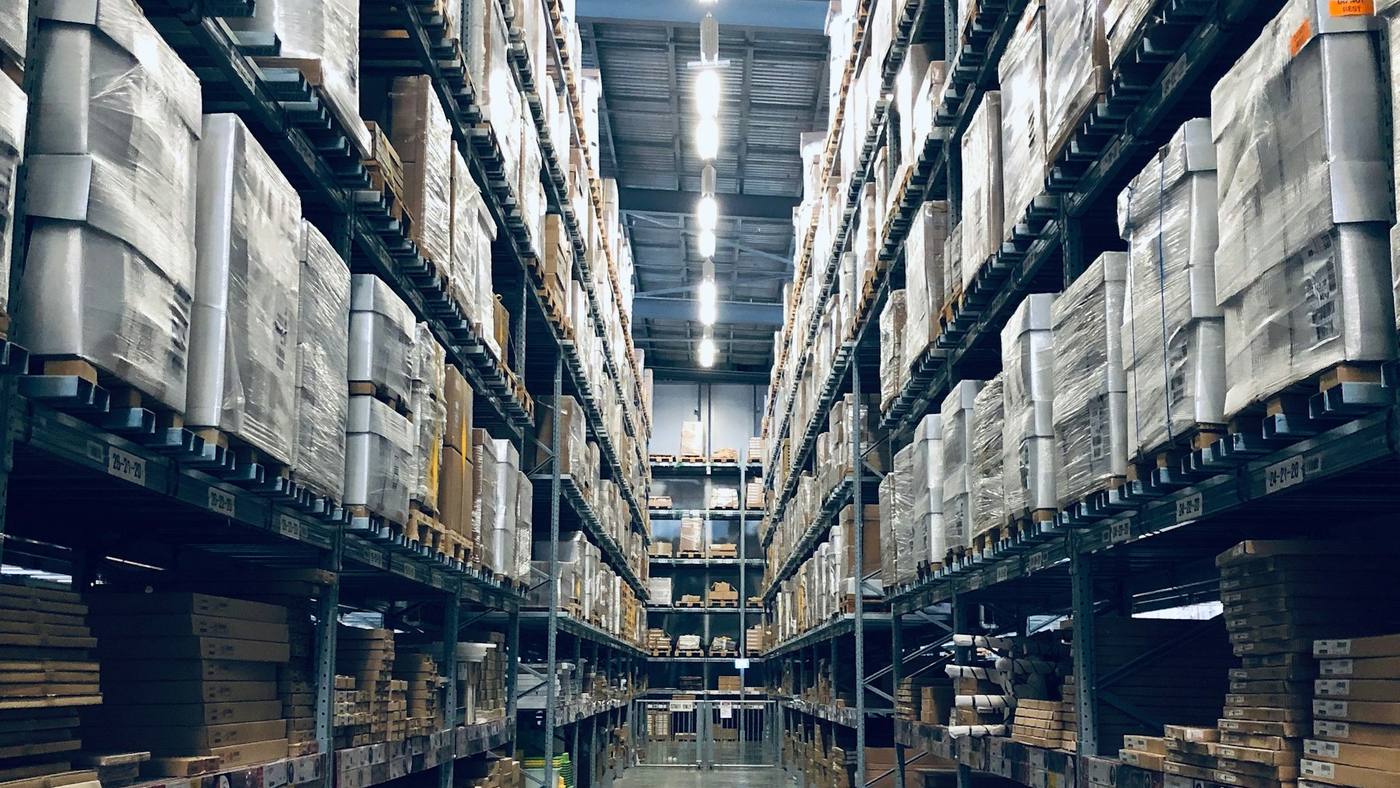 Pallets stacked to the roof along the aisle of a storage warehouse